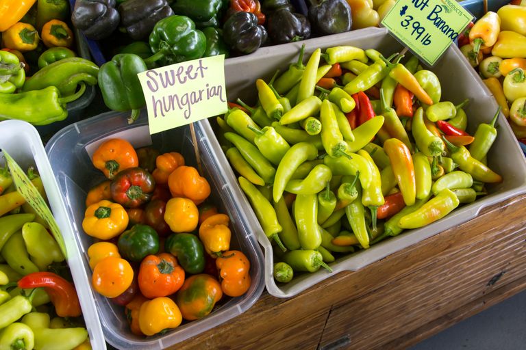 Vibrant display of peppers at a farmer's market showing sweet Hungarian and banana peppers.